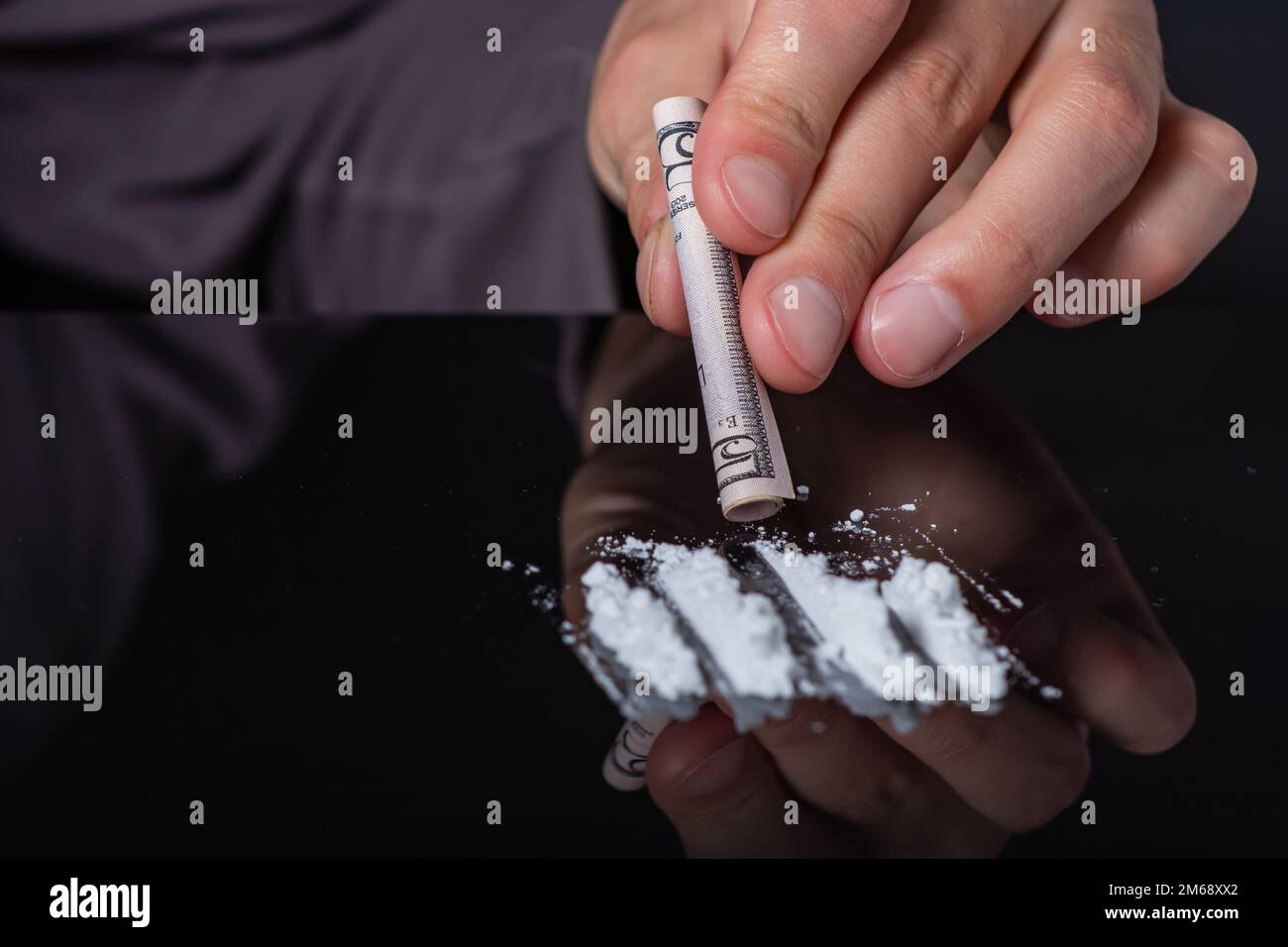 Concept de toxicomanie.. Abus de drogues, homme prenant des drogues, ronflements de lignes de poudre de cocaïne, gros plan. Banque D'Images