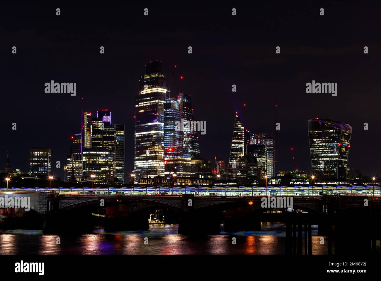 Vue magnifique sur le paysage de la ville de Londres depuis le front de mer de la Tamise la nuit, prise de vue à main levée. Concept de croissance rapide et de développement urbain. Banque D'Images