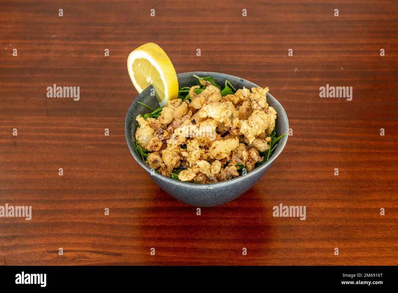 Les puntillitas sont préparés comme des poissons frits précédemment farinés et servis chauds sur une assiette ouverte. Généralement accompagné d'un citron Banque D'Images