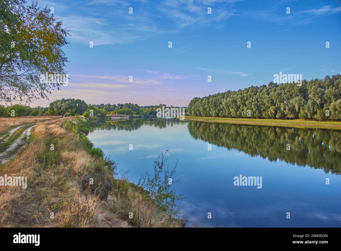 Une rivière entourée de champs et d'arbres Banque D'Images