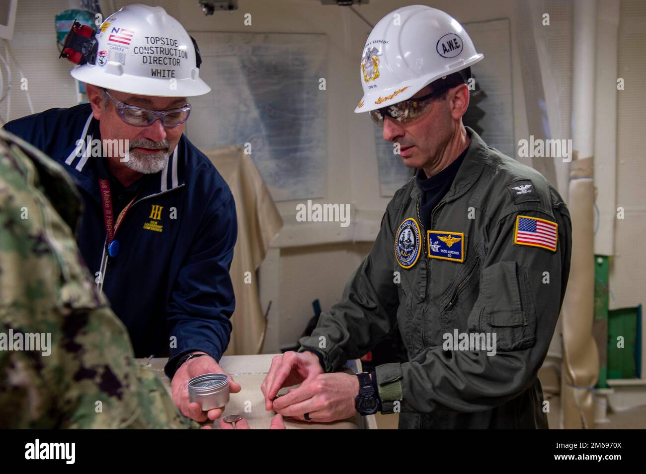 NEWPORT NEWS, Virginie (21 avril 2022) le capitaine Todd Marzano, commandant du porte-avions, de l'unité de pré-mise en service (PCU) John F. Kennedy (CVN 79) et Dave White, directeur de la construction de la division Newport News Shipbuilding (NNS) de HII, passent en revue les éléments placés dans la capsule du temps d'atterrissage de l'île dans le contrôle du pont de vol à bord du navire. La capsule temporelle sera ouverte à l’avenir lors du ravitaillement en carburant et de la révision complexe de John F. Kennedy. John F. Kennedy, deuxième porte-avions de la classe Ford, est en construction à NNS, Newport News, en Virginie. Banque D'Images