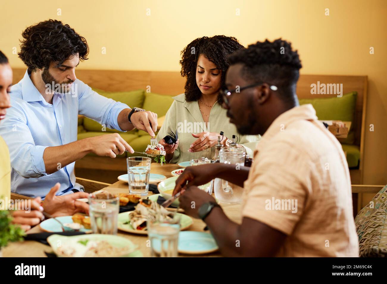 Groupe de quatre amis qui déjeunent dans un restaurant. Concept de réunion et de célébration. Banque D'Images