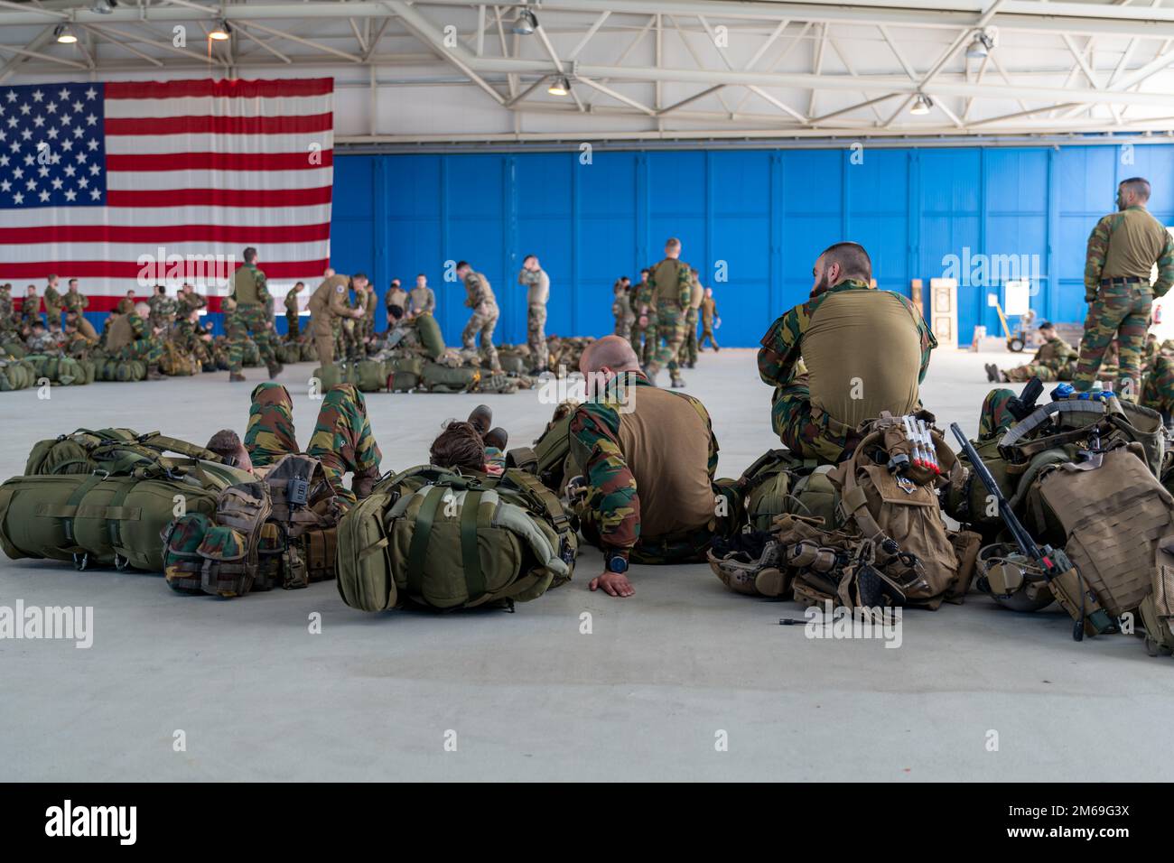 Les parachutistes paramédiques belges sont au repos d'une mission précédente et regardent leurs pairs, affectés au bataillon du Commando 2nd, Régiment des opérations spéciales, complétés par les parachutistes français du Régiment des parachutistes d'infanterie marine 8th, Brigade de parachutistes 11th, se préparer pour un saut pendant l'opération Nemesis, sur la base aérienne de Chièvres, Belgique, 20 avril, 2022. Opérations Nemesis était un exercice conjoint de plusieurs jours entre les forces belges et françaises, qui se sont déployées à partir de la base aérienne de Chièvres pour exécuter des missions dans plusieurs endroits du pays. Banque D'Images