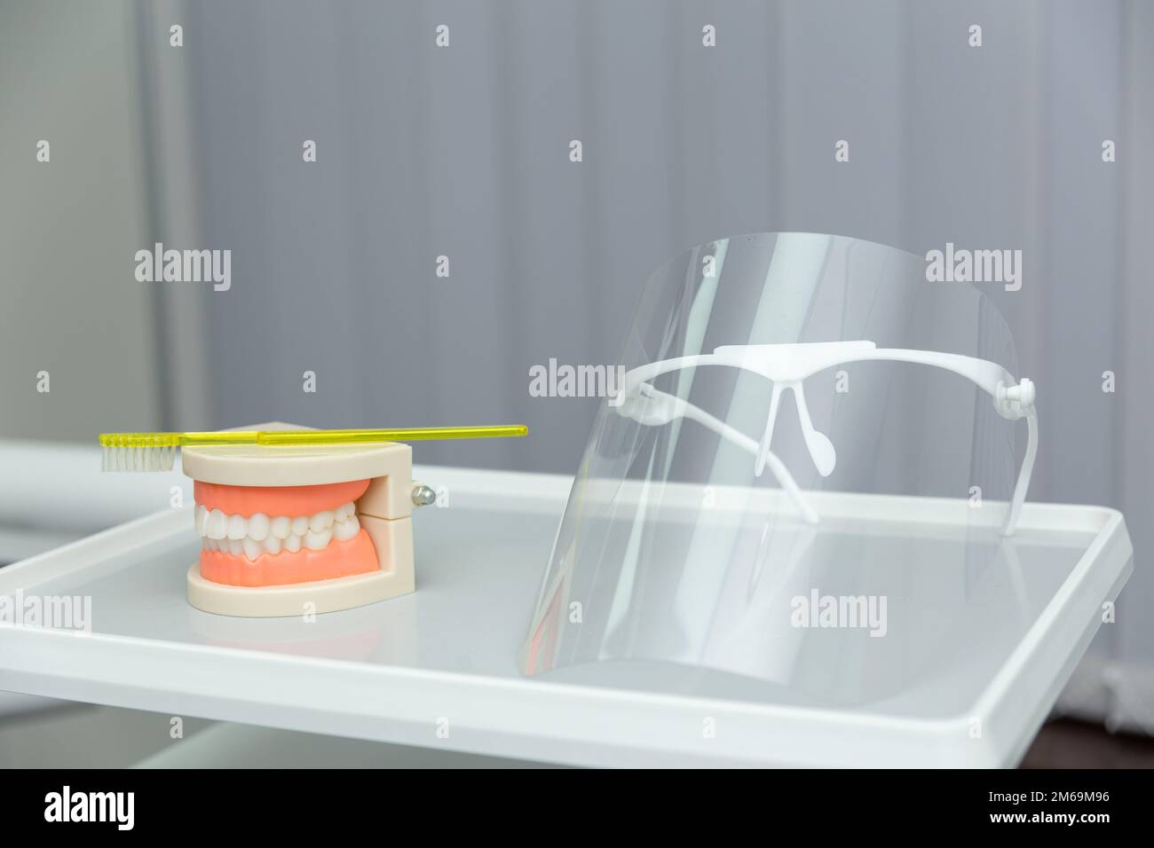 Nettoyer les dents modèle de mâchoire dentaire et brosse à dents jaune sur fond gris. Le concept de soins buccaux appropriés, l'hygiène des caries. Comment nettoyer les dents avec Banque D'Images