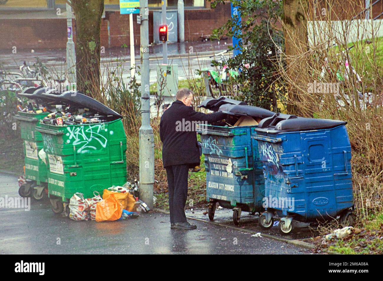 Glasgow, Écosse, Royaume-Uni 3rd janvier 2023. Météo au Royaume-Uni : l'homme utilisant des bacs de recyclage ignore les bennes à ordures sur Maryhill Road. Les températures glaciales ont laissé place à des conditions météorologiques de rêve alors que les rues sont mouillées pendant la nuit avec des averses légères. Crédit Gerard Ferry/Alay Live News Banque D'Images