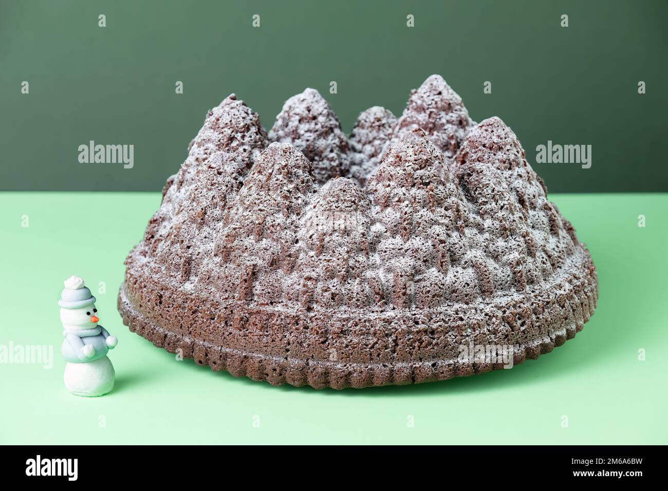 Un gâteau au chocolat de Noël festif. Le gâteau est fait à l'aide d'un moule Bundt pour former la pâte à gâteau dans les formes d'arbre. Une saupoudrez de sucre glace Banque D'Images