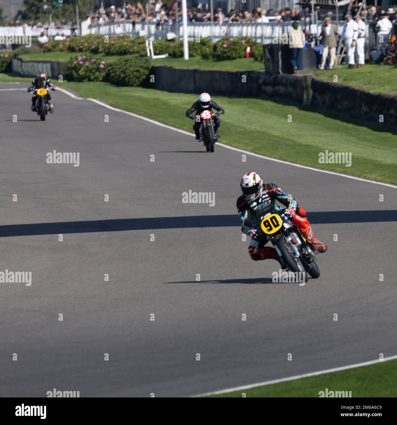 La moto n° 90 mène deux autres dans le virage au Goodwood Revival 2022 Banque D'Images
