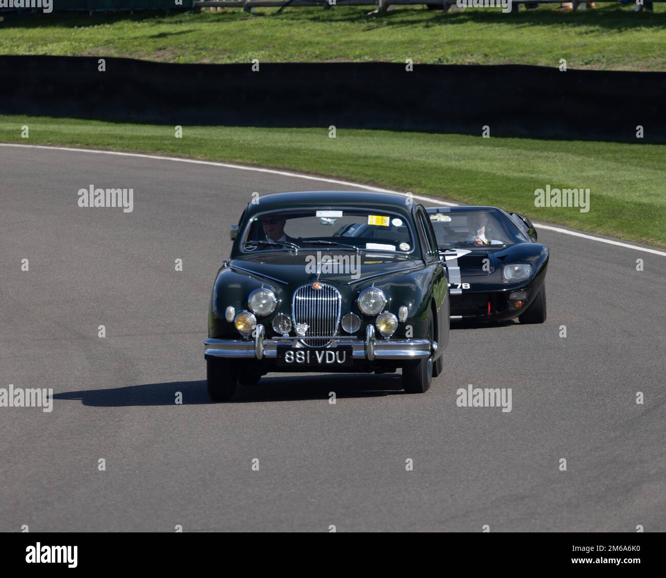 Une berline Jaguar 1958 verte dirige une ford GT40 lors du Goodwood Revival 2022 Banque D'Images