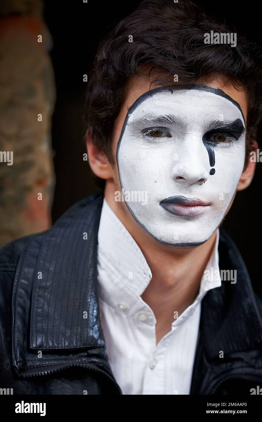 Guy mime contre un vieux mur de briques. Banque D'Images