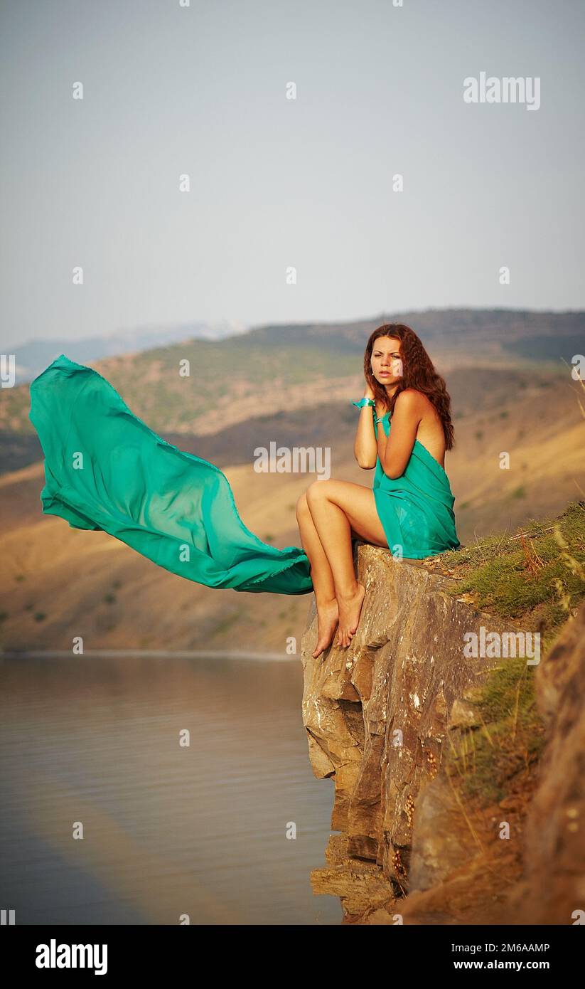 Fille assise sur le bord d'une falaise Banque D'Images