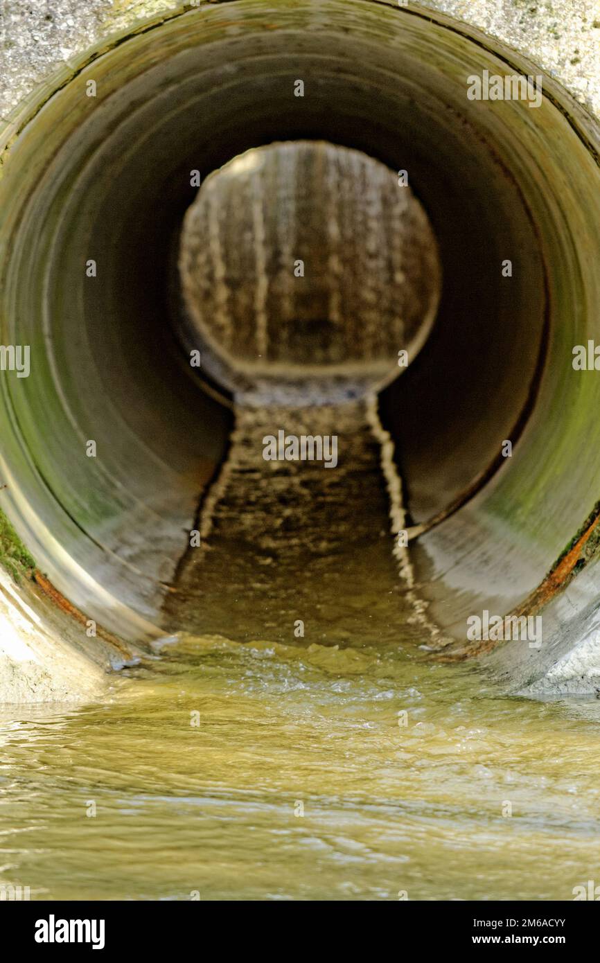 Tuyau de système de drainage pour l'eau de pluie qui coule dans un fossé.  Une promenade en brique à travers elle. Campagne russe Photo Stock - Alamy