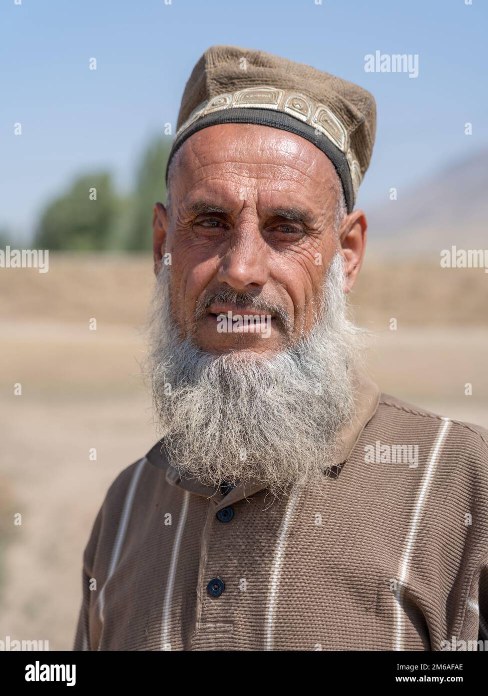 Près de Kulob, Khatlon, Tadjikistan - 08 21 2019 : portrait en plein air d'un fermier d'âge moyen tadjik barbu portant une calotte ethnique traditionnelle dans son champ Banque D'Images