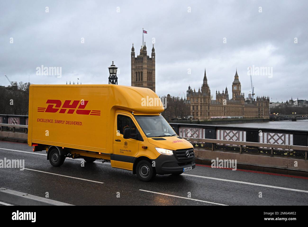 Minibus de livraison DHL sur le pont Lambeth. Chambres du Parlement et Big Ben en arrière-plan. Londres. Janvier 2023. Banque D'Images