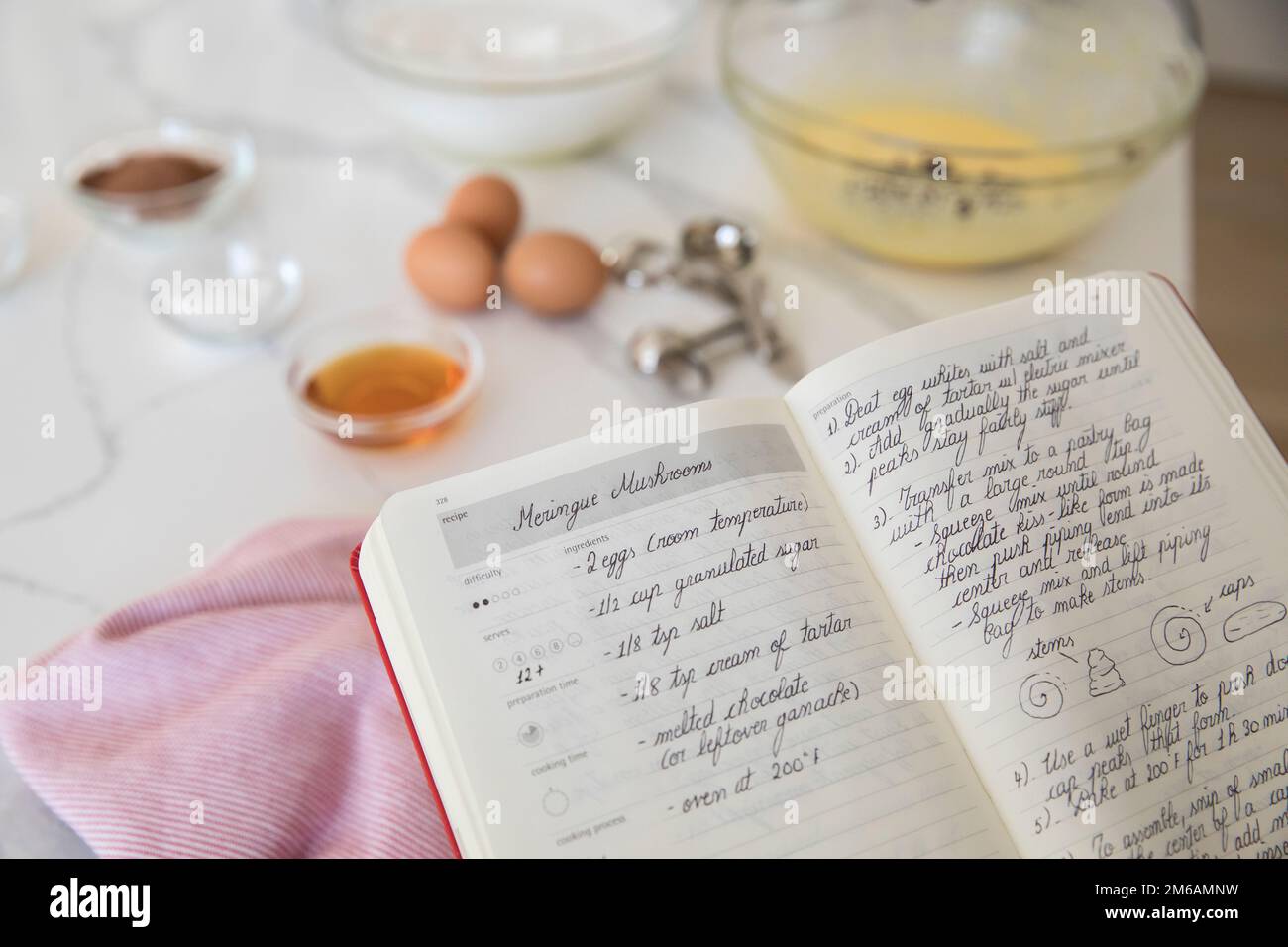 Recette de mérigue dans un livre de recettes avec des ingrédients de boulangerie Banque D'Images