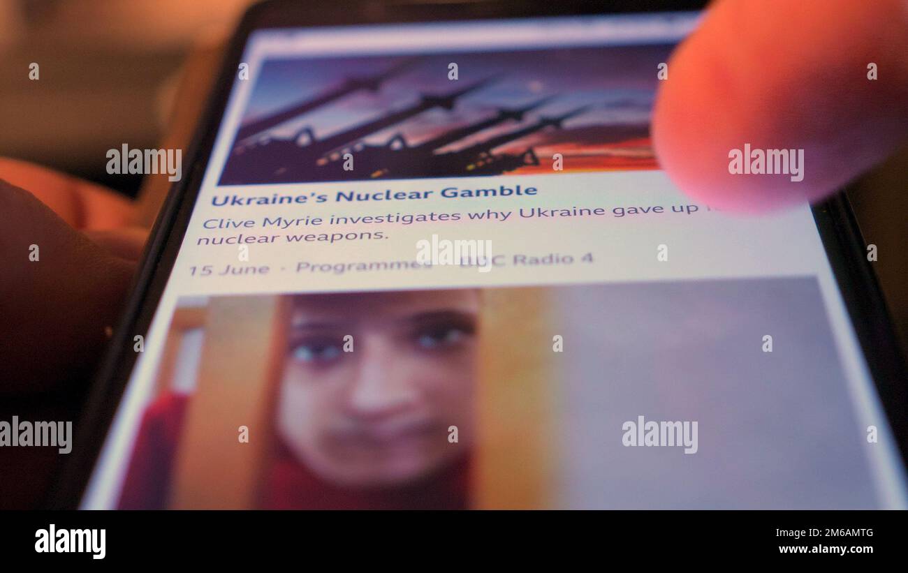 Faire défiler les actualités de la BBC en Ukraine sur un téléphone portable. Visage enfant. Banque D'Images