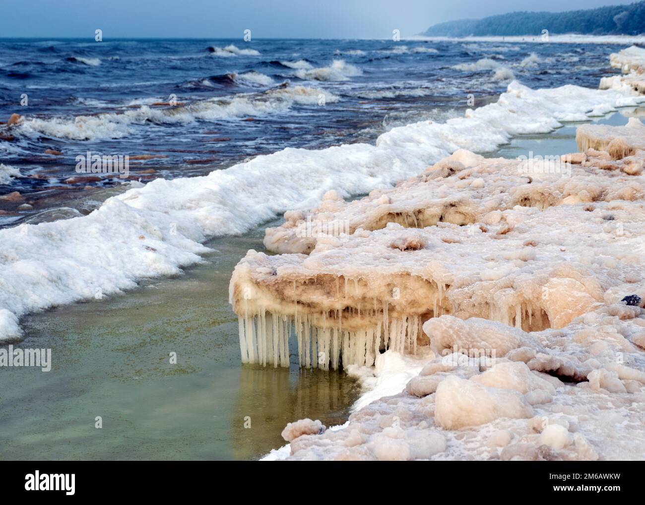 Des morceaux de glace couchés sur la mer, des glaçons de différentes tailles se reflètent dans les textures d'eau, de sable et de glace des dunes, de la mer Baltique, de la Lettonie Banque D'Images