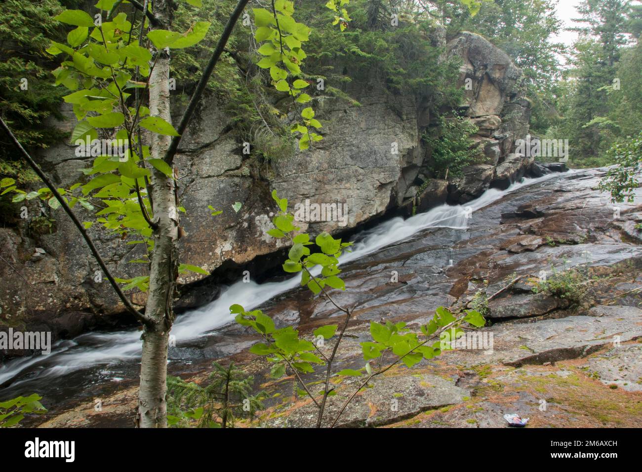 Chute d'eau sous un rocher Banque D'Images