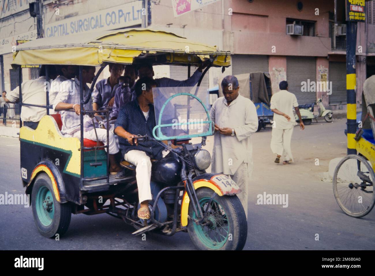 Historique, Archive image d'Un homme payer son prix à Un chauffeur de la maintenant interdite Phat Phati Auto Rickshaw taxi transportant des passagers basés sur Une moto Harley Davidson de la Seconde Guerre mondiale, Delhi, Inde, août 1990 Banque D'Images