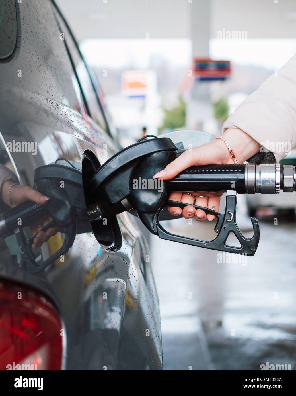 Femme pompant de l'essence dans la voiture à la station-service. Concept d'augmentation du prix de l'essence ou de l'essence. Banque D'Images