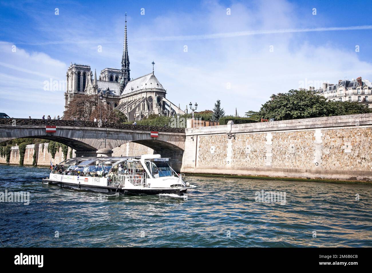 Un bateau touristique sur la Seine navigue par notre Dame sous le pont Archeveche à Paris, France. Banque D'Images