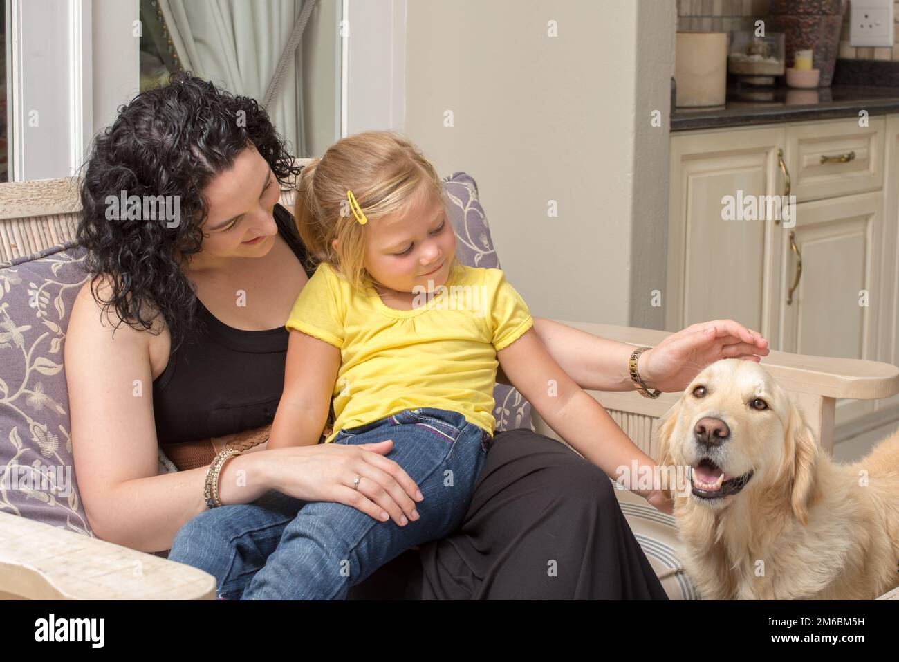 Mère et fille avec Golden Retriever on Porch Banque D'Images