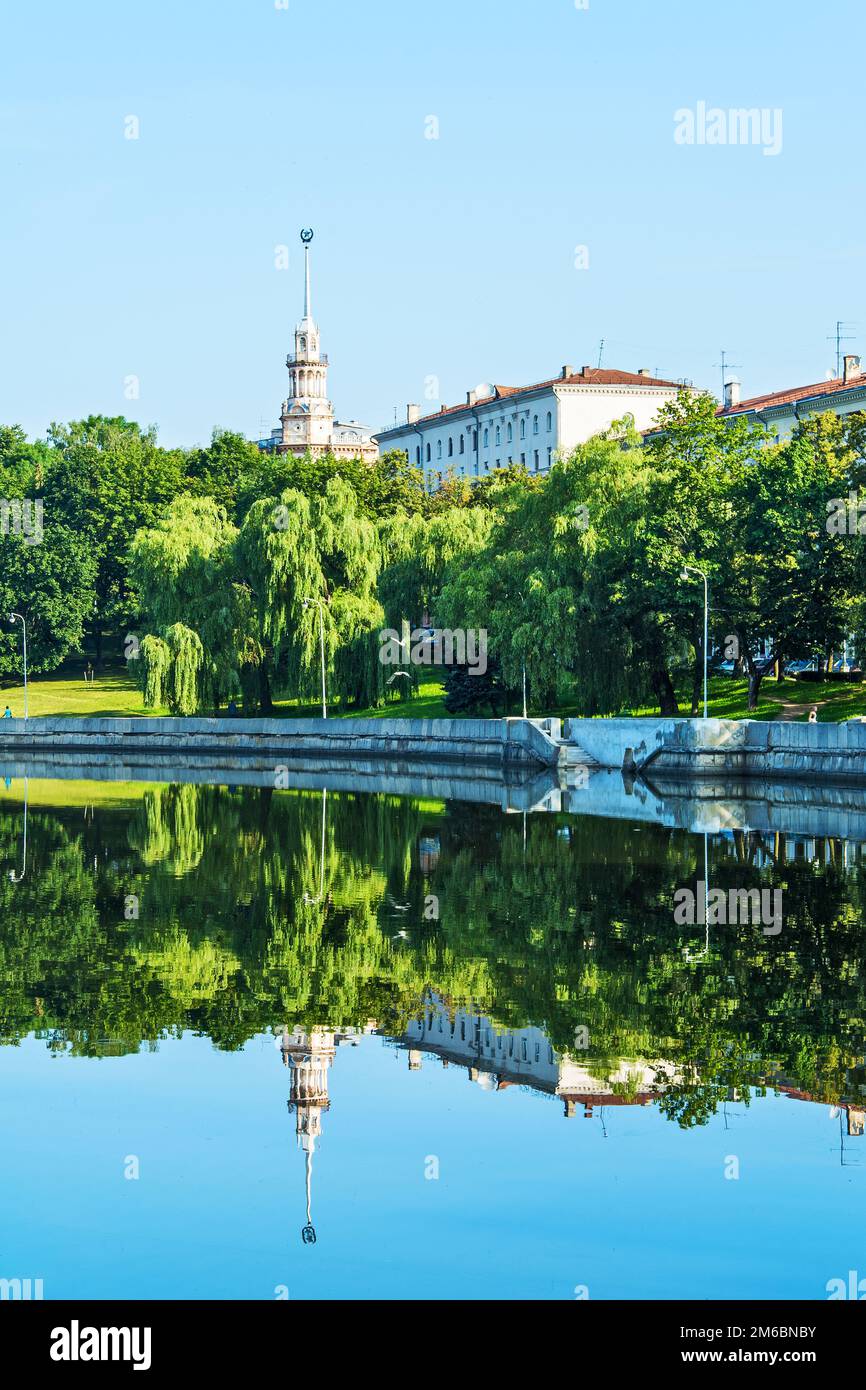 Paysage de la ville avec rive de réflexion dans l'eau calme de la rivière. Banque D'Images