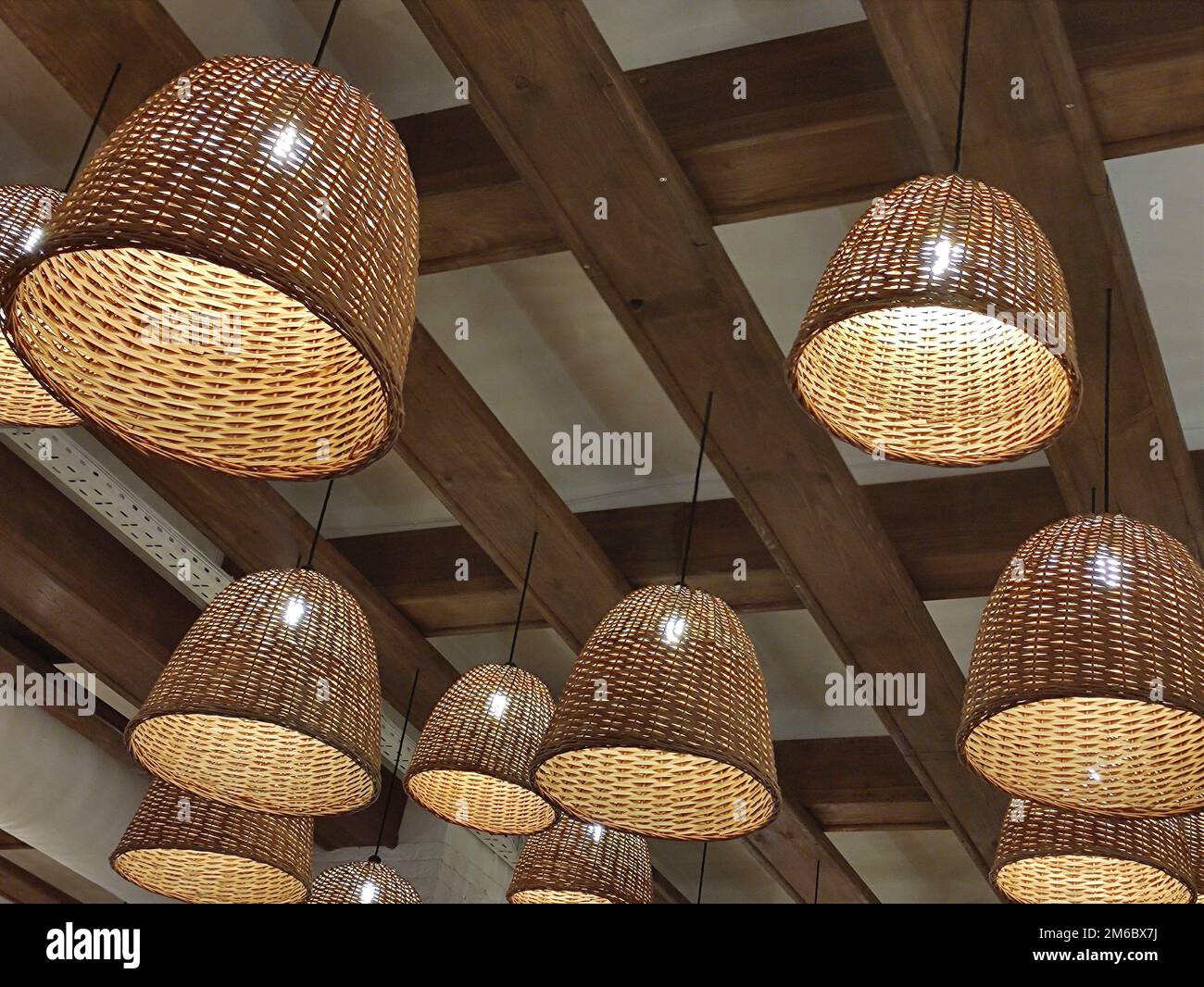 Arrière-plan des lampes électriques. Beaucoup de lampes dans des paniers suspendus sur un plafond en bois Banque D'Images