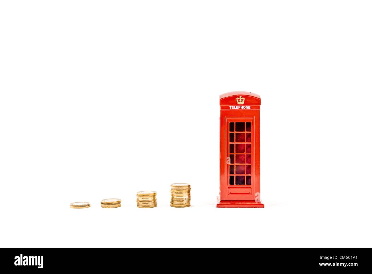 Cabine téléphonique rouge avec des pièces de monnaie empilées money Box london, Penny ou piggy Bank sur fond blanc. Idée de réaliser des économies photo hd. Boîte à économie d'argent. Banque D'Images