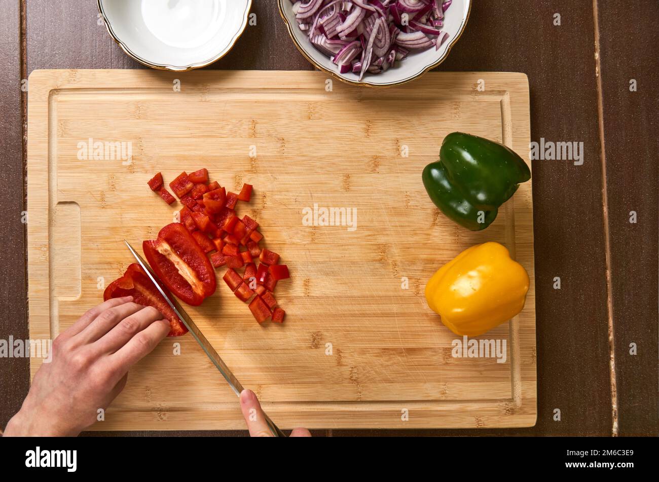 Man's hands couper des légumes frais dans la cuisine, préparer un repas pour le déjeuner. Vue du haut vers le bas. Banque D'Images