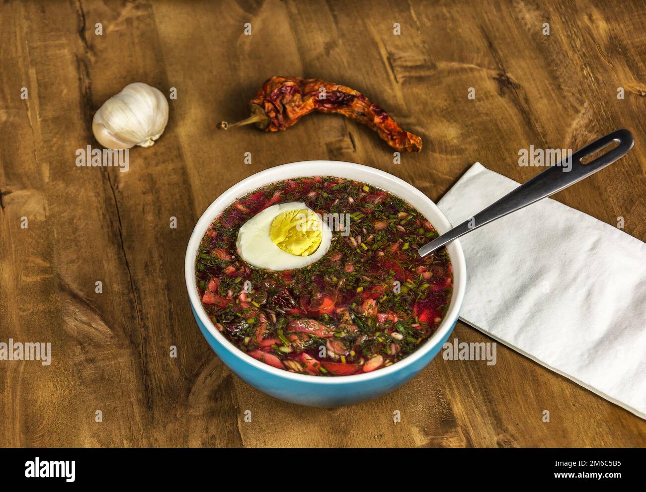 Sur une table en bois bleu est un bol de soupe de légumes et d'oeufs Banque D'Images