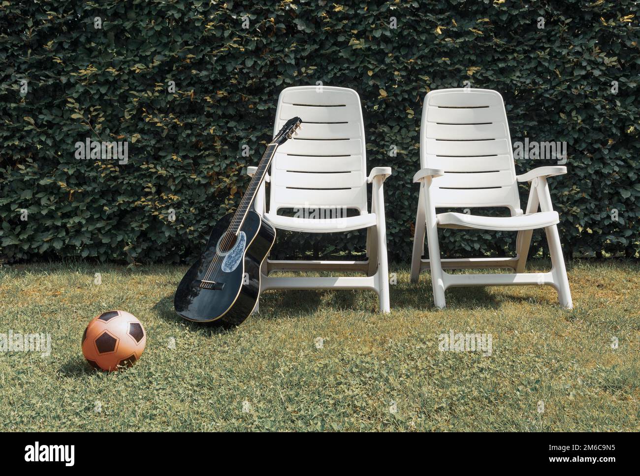 Fin de l'été. Deux chaises de plage vides, guitare et ballon. Arrêter la lecture Banque D'Images