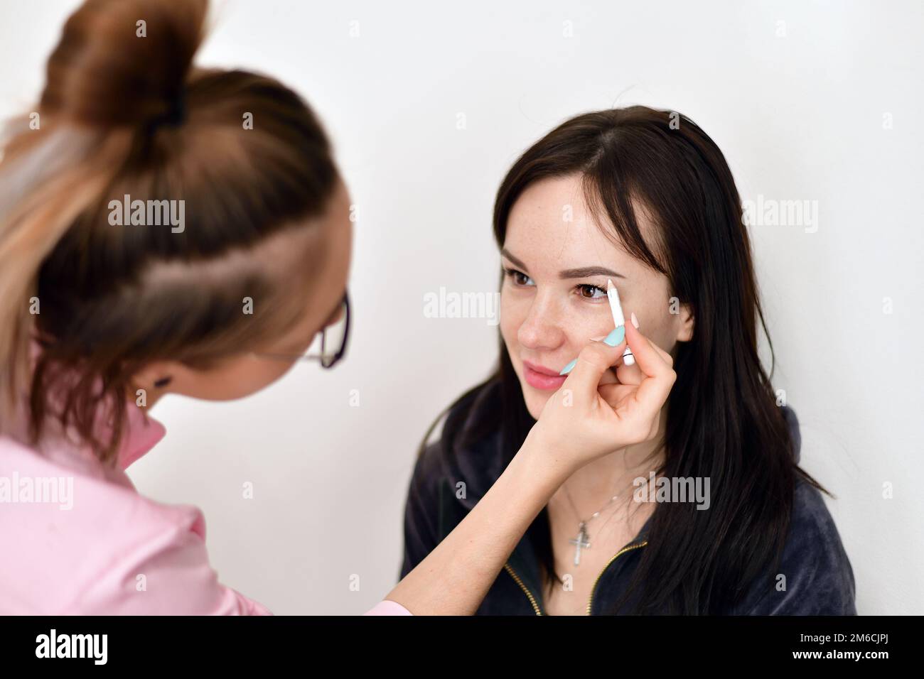 Maquilleuse peint les sourcils pour la jeune fille Banque D'Images