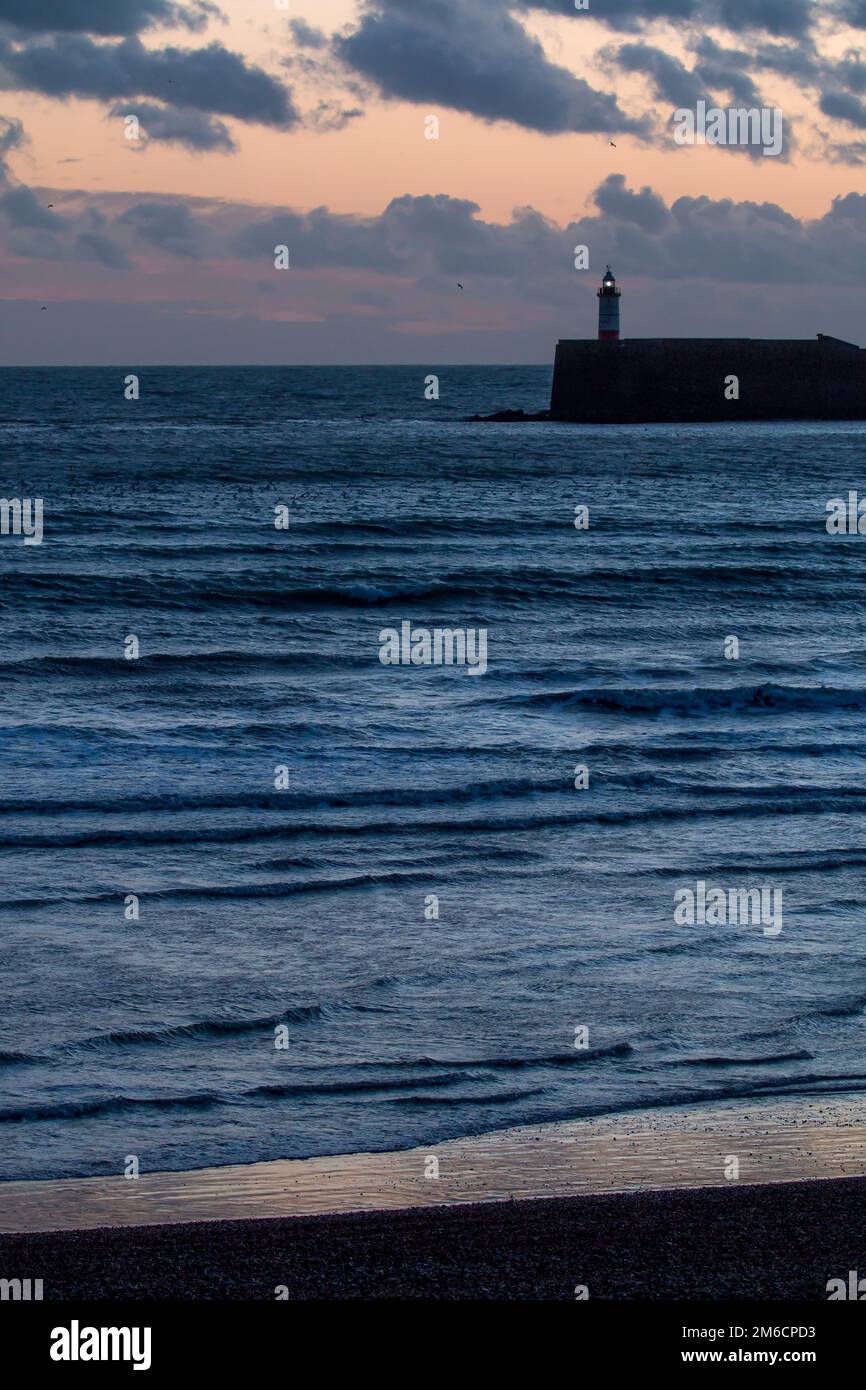 Phare de Newhaven et Seaford plage au coucher du soleil Banque D'Images