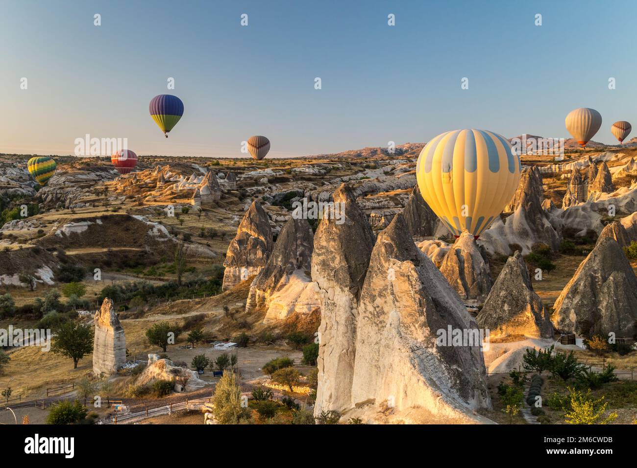 Ballons d'air chaud volant au lever du soleil sur des formations rocheuses à Cappadoce, Turquie Banque D'Images