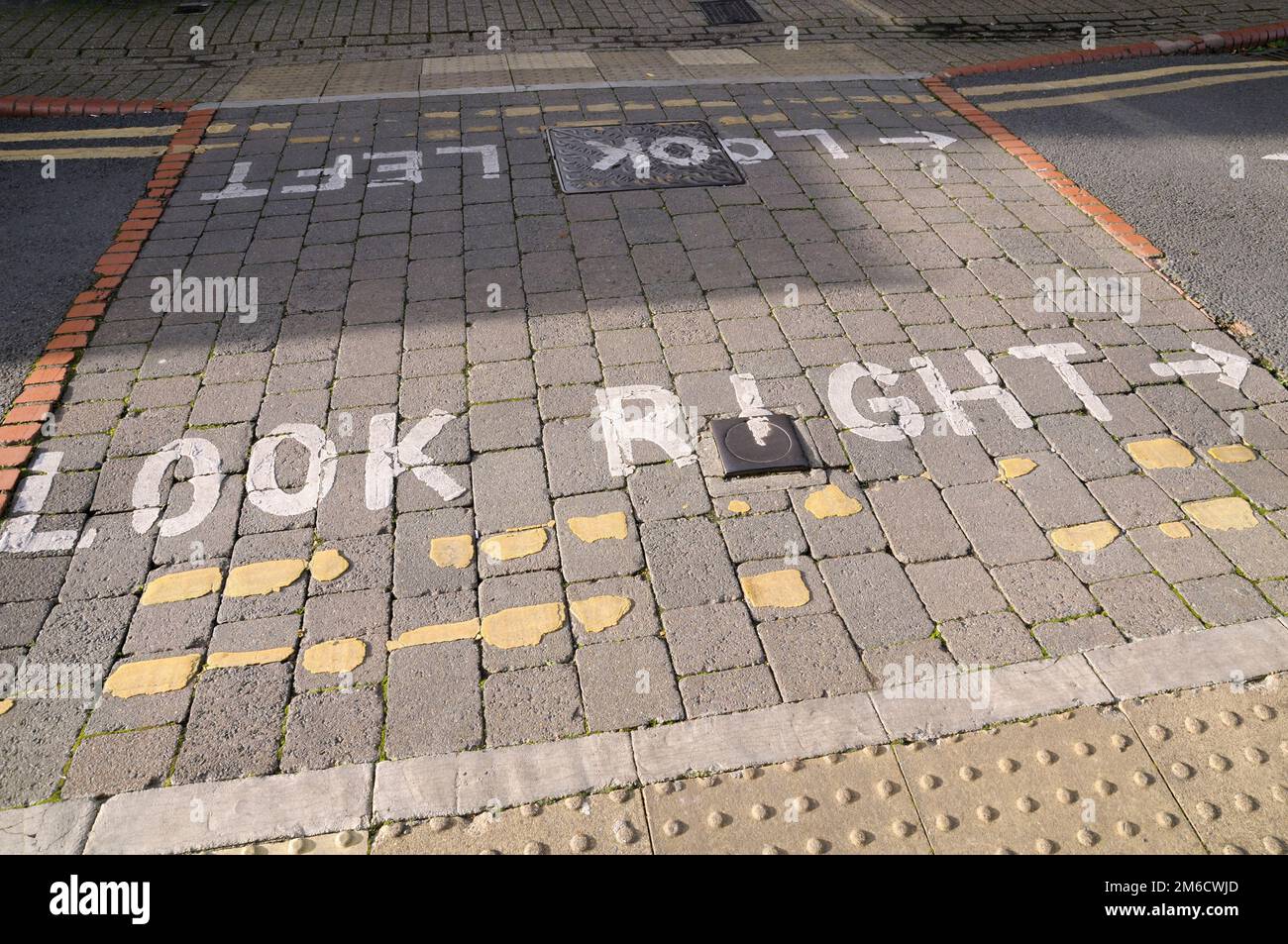 Détail des marquages routiers look right et look left peints sur un passage à niveau pour piétons du Royaume-Uni Banque D'Images