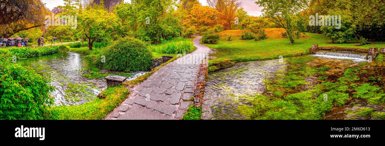 Jardin d'eden enchanté pont au-dessus de l'étang dans le jardin horizontal panoramique de Nymph ou Giardino della Ninfa en Latium - Italie Banque D'Images