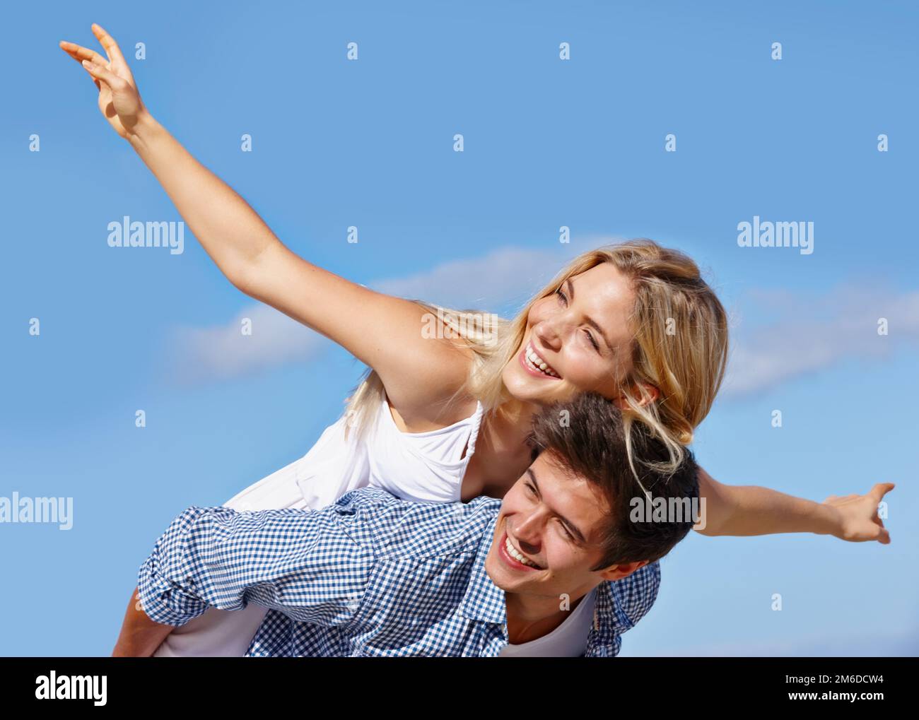 S'amuser au soleil. un jeune couple heureux qui profite d'une promenade en plein air. Banque D'Images