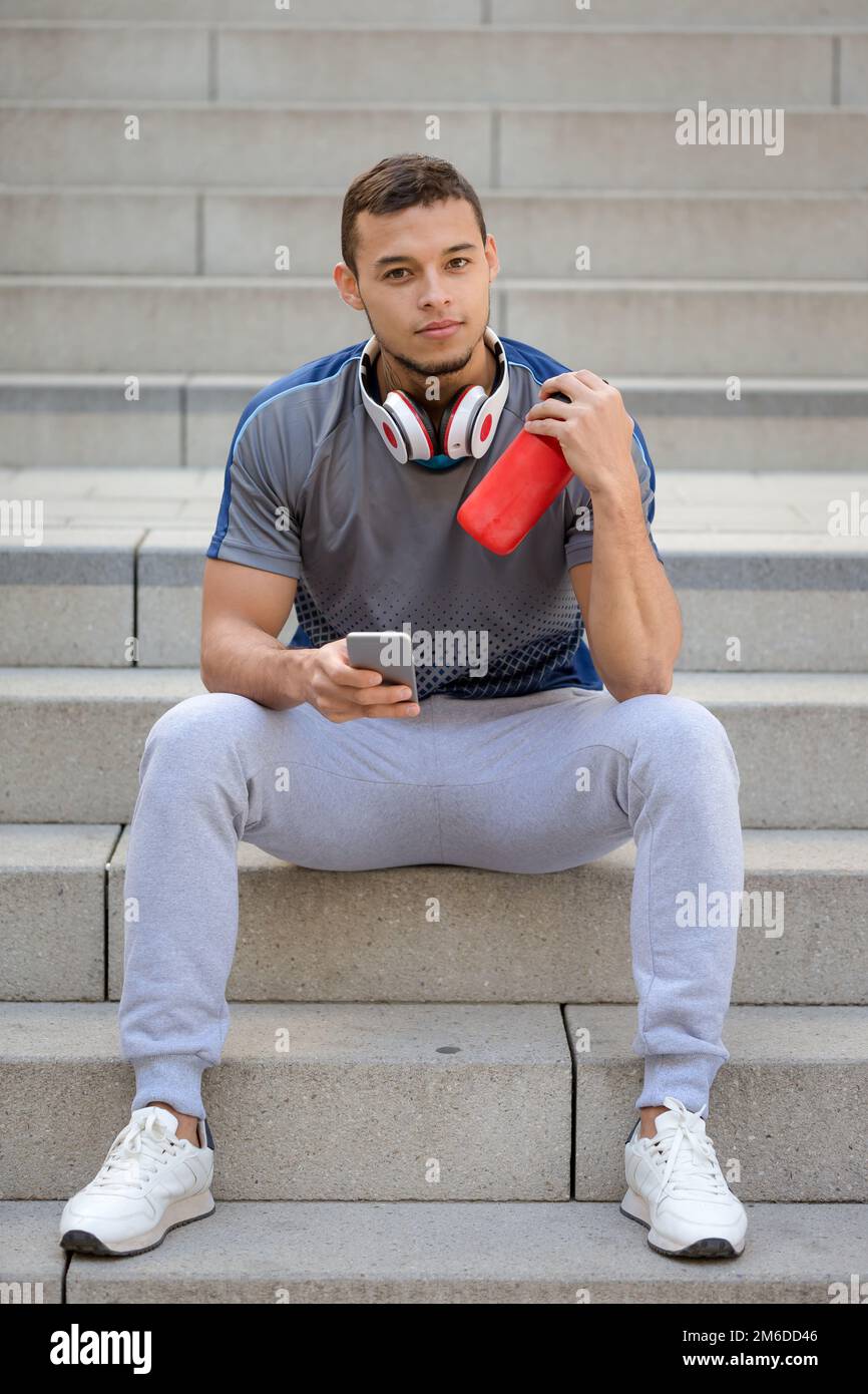 Smartphone jeune latin homme coureur jogger sport format portrait Banque D'Images