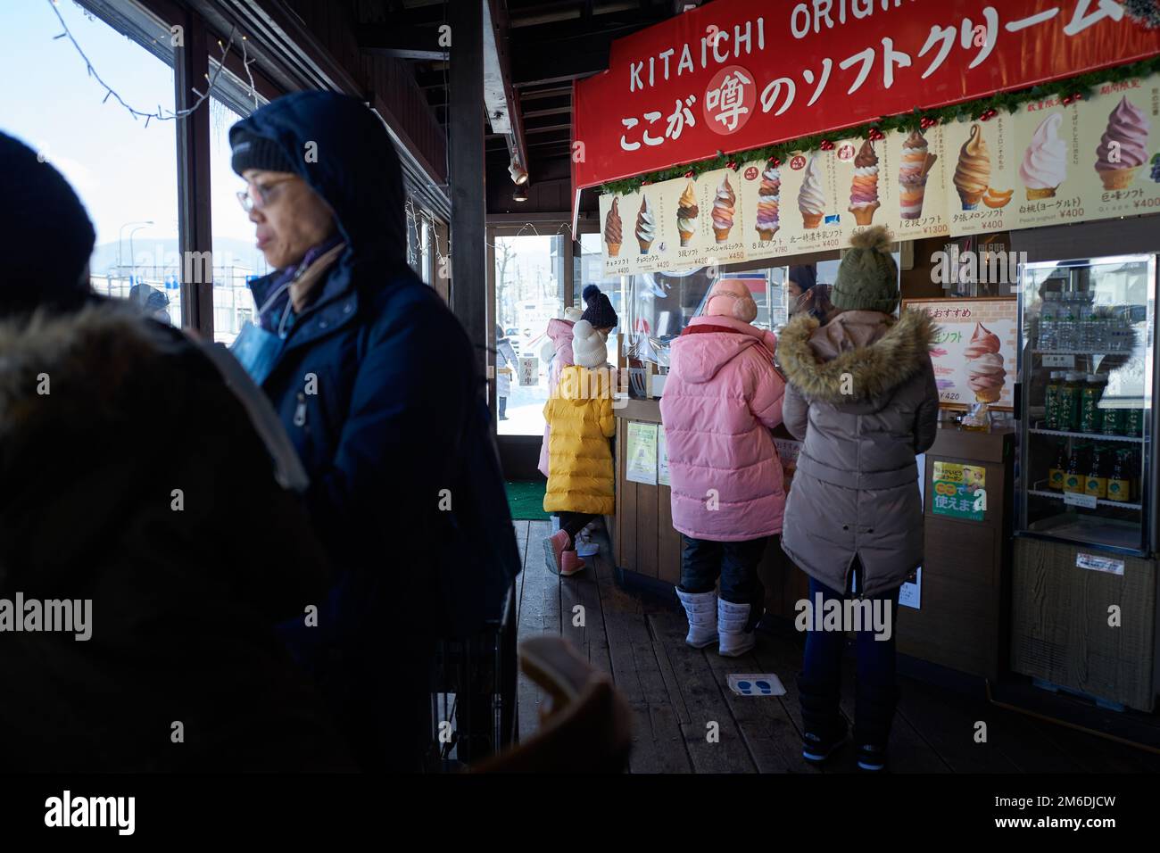 Otaru, Japon - 19 décembre 2022: Les touristes achètent de délicieuses glaces colorées à la célèbre boutique de glaces à Otaru Banque D'Images