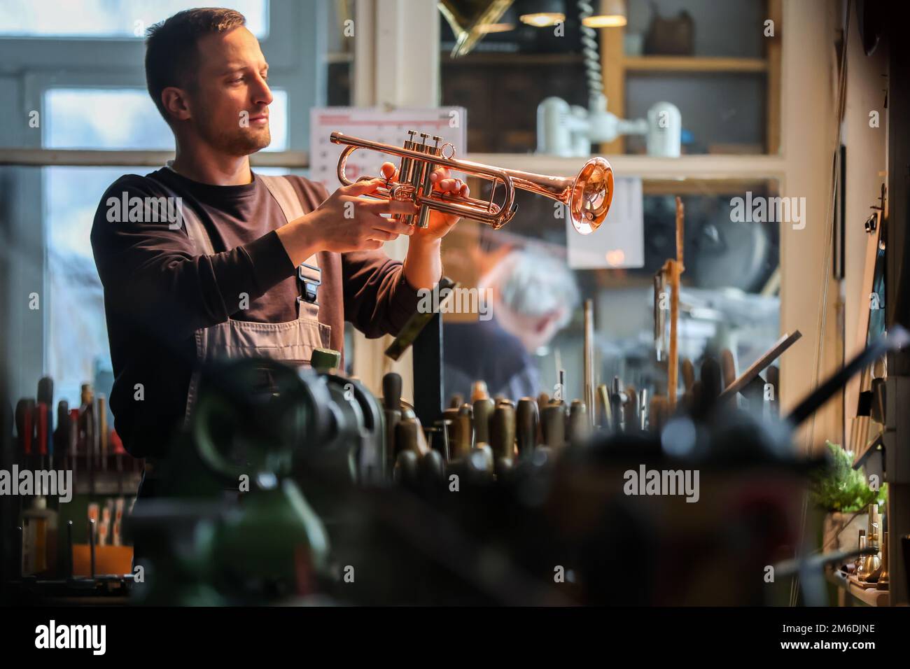 20 décembre 2022, Saxe, Markneukirchen: Le fabricant d'instruments Max  Hertlein regarde sa trompette 'la Rossa' en cuivre dans l'atelier de la  société familiale Werner Chr. Schmidt. L'instrument ne contient pas de  métaux lourds. Normalement, les ...