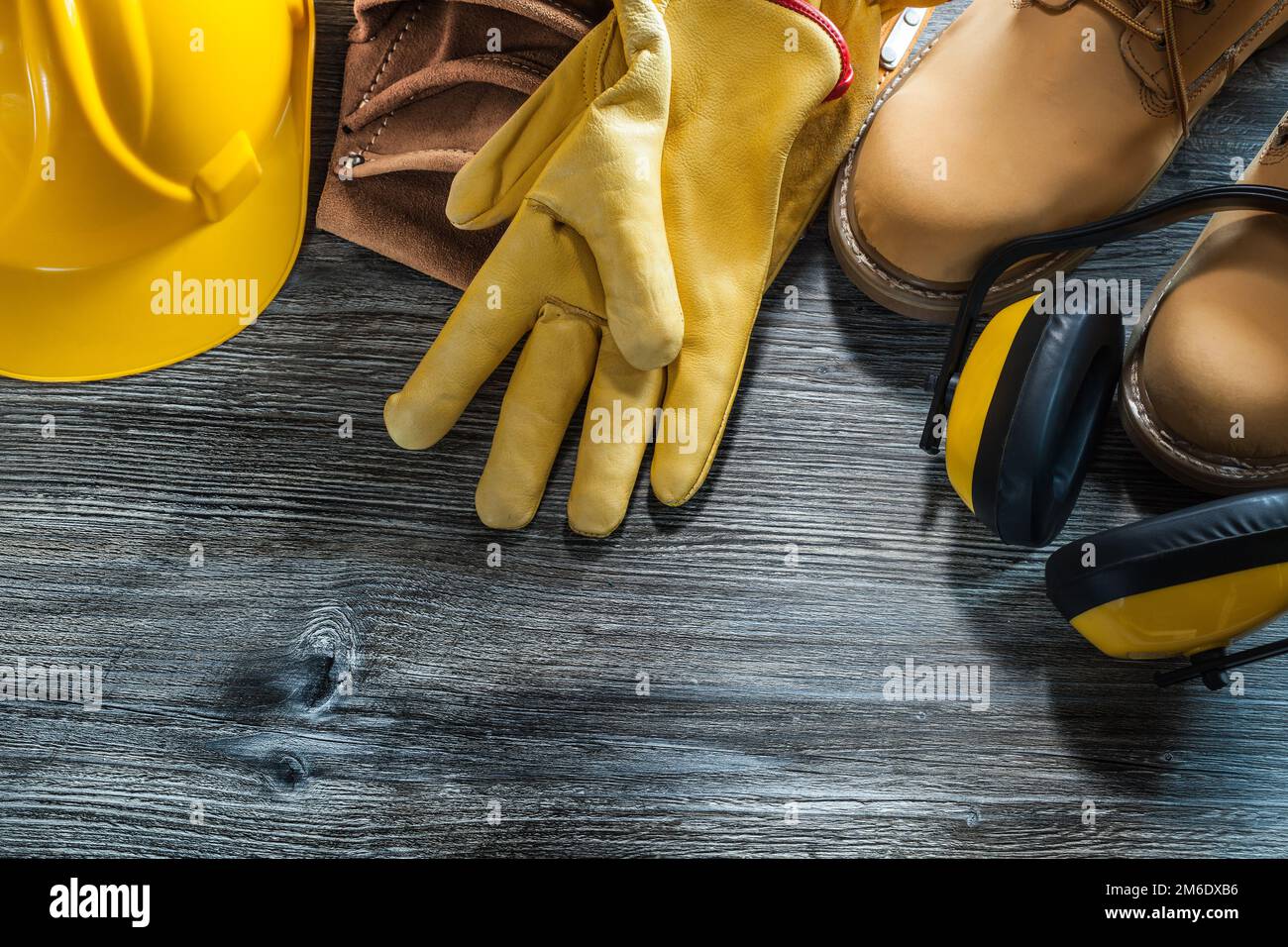 Gants de protection en cuir capuchon bottes porte-outils casque antibruit  sur panneau en bois Photo Stock - Alamy