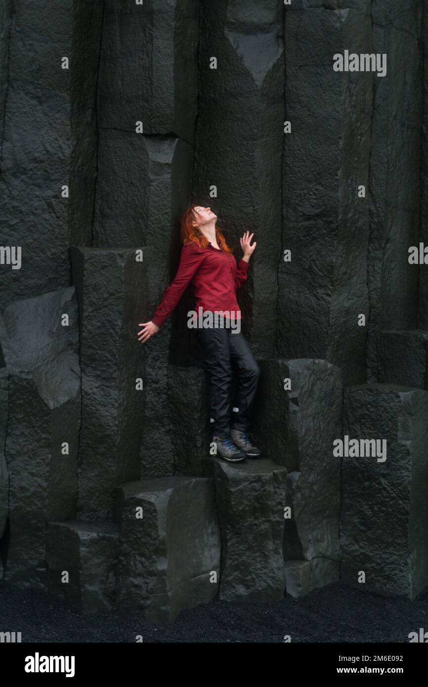 Femme courageuse posant sur des colonnes de basalte photographie pittoresque Banque D'Images