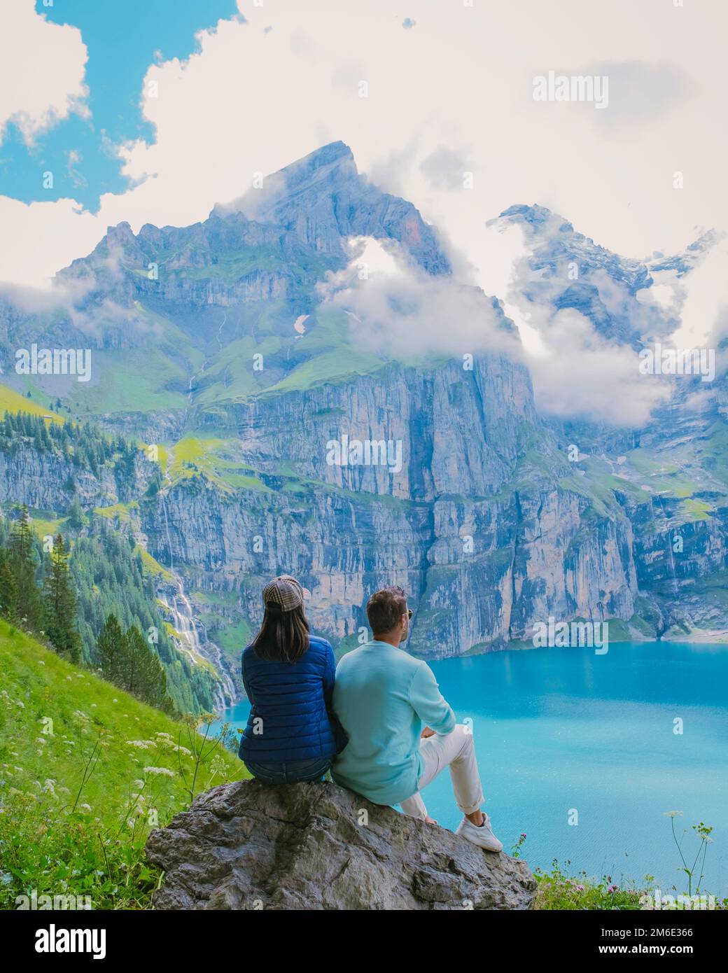 Couple visite du lac Oeschinensee. Une merveilleuse scène en plein air dans les Alpes suisses avec montagne Bluemlisalp, emplacement du village de Kandersteg, couple de randonnée au bord du lac, homme et femme Banque D'Images