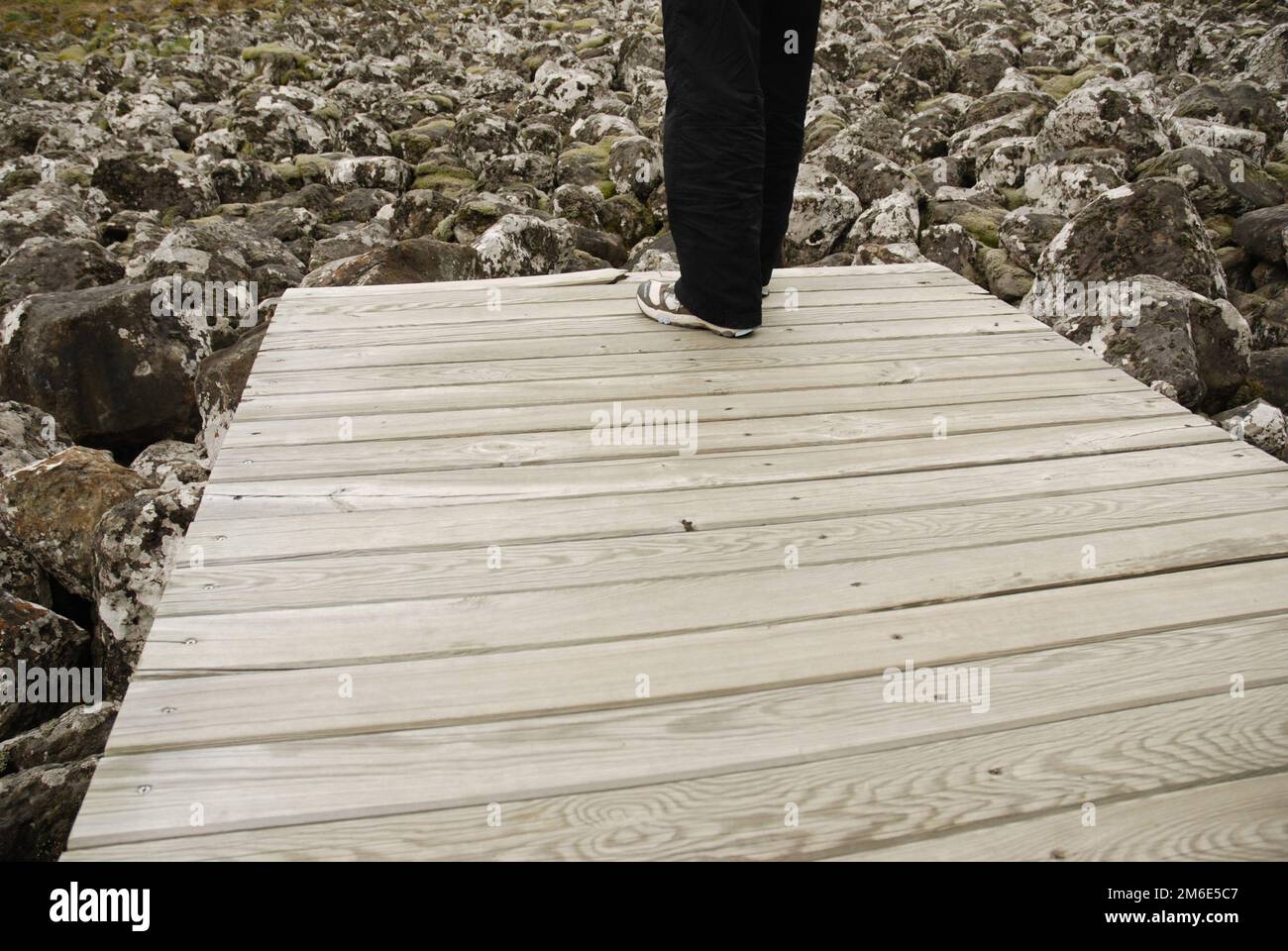 Une personne est debout sur le bord d'un quai et il n'y a que des pierres sous lui. Banque D'Images