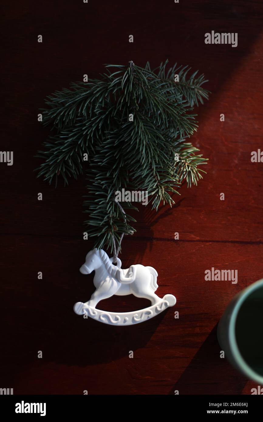Arbre de Noël, cheval jouet, boîte cadeau, cône de pin sur une table en bois vue de dessus. Nouvelle année décoration de maison Banque D'Images