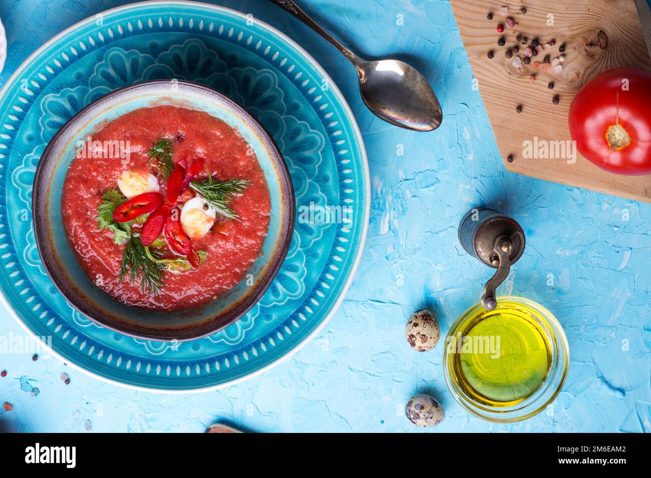Soupe froide traditionnelle espagnole à l'état brut Gazpacho servie à table bleue. pose à plat. recette de nourriture. concept sain. Banque D'Images