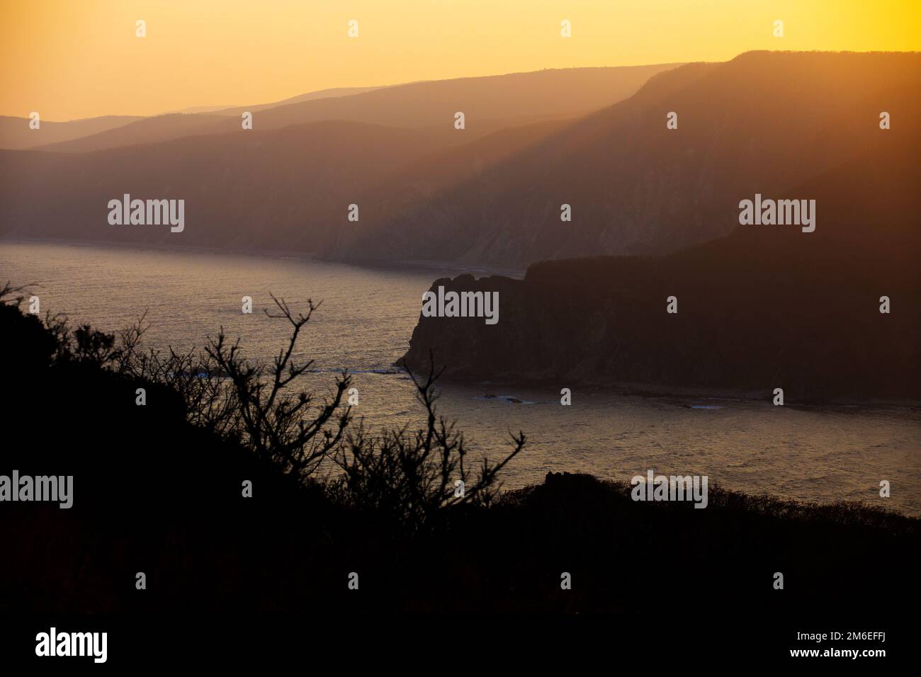 Réserve de biosphère de Sikhote-Alin dans le territoire de Primorsky. Les rayons du soleil couchant font leur chemin à travers la côte rocheuse de Banque D'Images