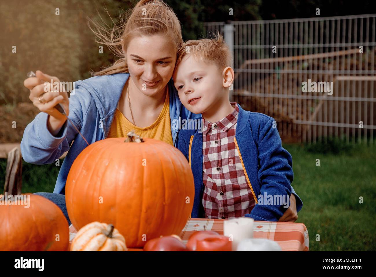 Un garçon et sa mère ont coupé une citrouille. Une jeune mère et son fils préparent une citrouille pour Halloween. Préparation pour Halloween. Peler Banque D'Images