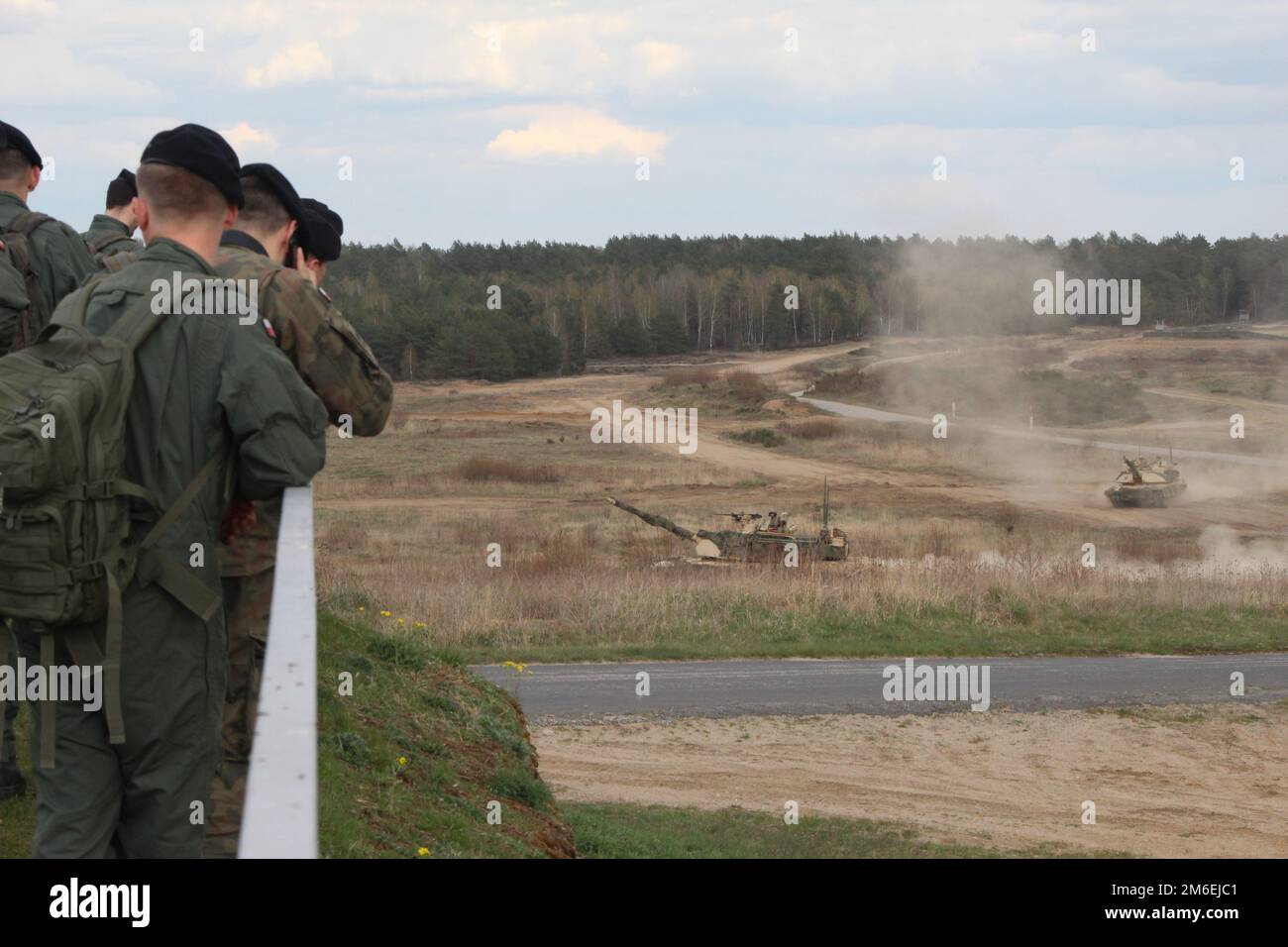 Les soldats polonais se tiennent à un point d'observation pendant que les chars d'assaut M1A2 Abrams passent au cours d'une promenade dans une chaîne de tir dans le cadre d'une classe de maître-canon lors du sommet des opérations d'Abrams à la chaîne de Bucierz, Drawsko Pomorskie, Pologne, 26 avril 2022. La Division d'infanterie de 1st est parmi les autres unités affectées au V corps, le corps de déploiement avancé des États-Unis en Europe qui travaille aux côtés des alliés de l'OTAN et des partenaires de sécurité régionaux pour fournir des forces crédibles au combat. Banque D'Images