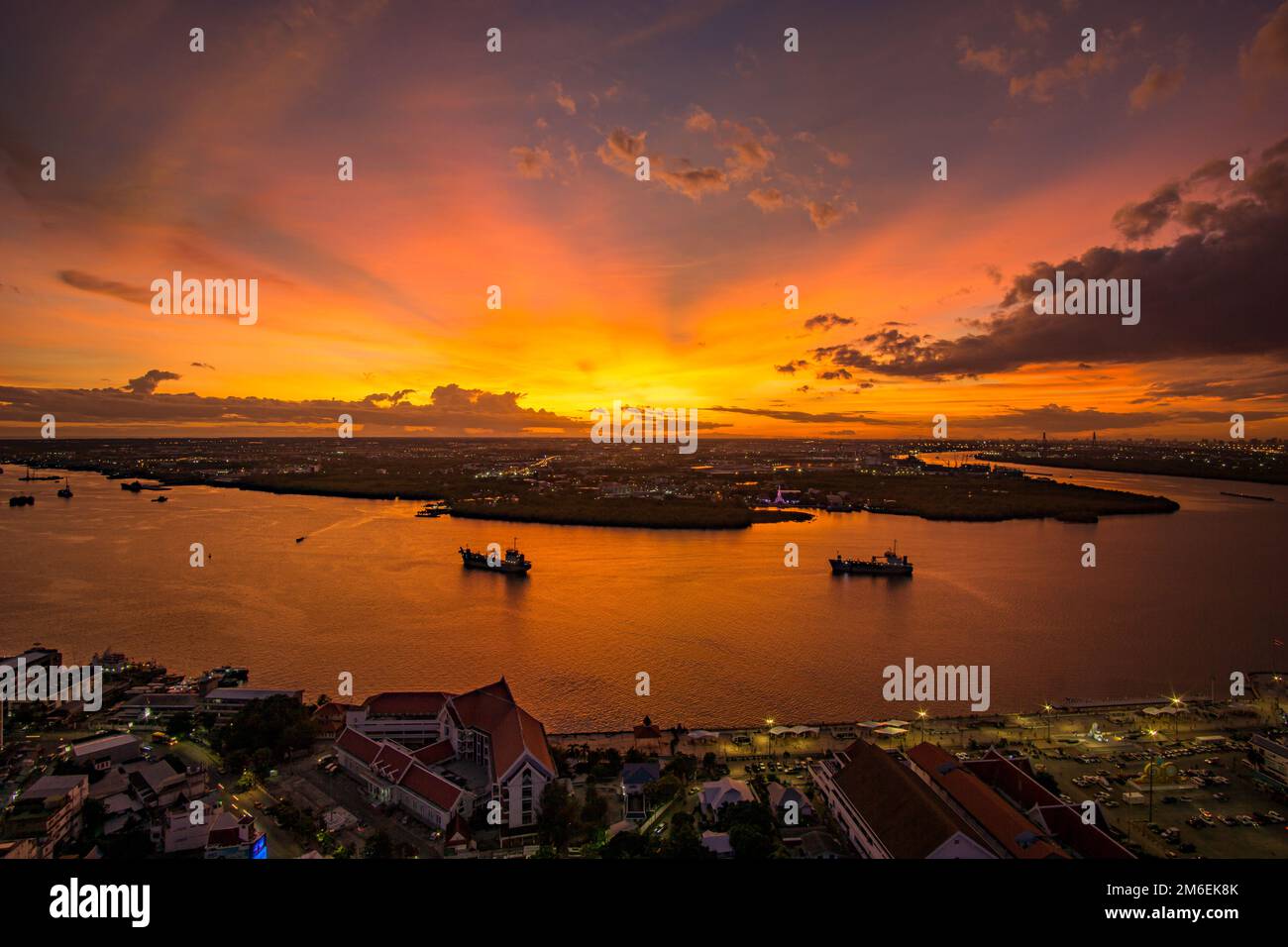 Vue panoramique sur Samut Prakan, Thaïlande. Coucher de soleil sur la rivière Chao Phraya, ciel orange. Banque D'Images